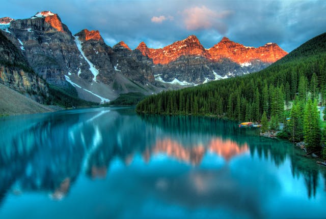 Snowy mountains, high trees, and a body of water in Alberta, Canada.